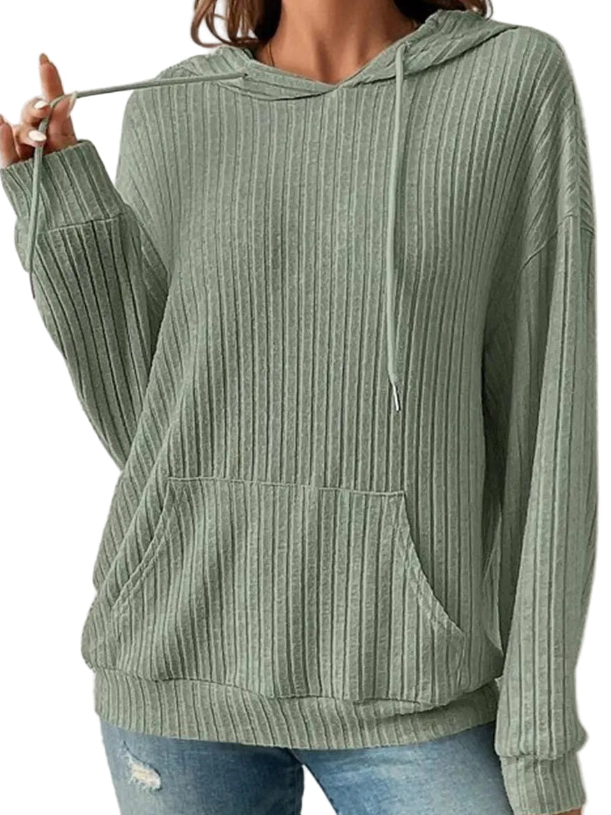 Person wearing a green ribbed hoodie and blue jeans against a white background